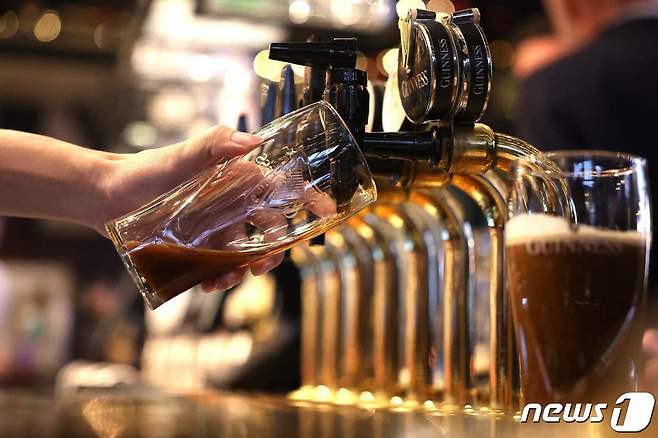 지난달 22일(현지시간) 영국 런던의 한 술집에서 종업원이 생맥주를 따르는 모습이다. 2023.11.22. ⓒ AFP=뉴스1