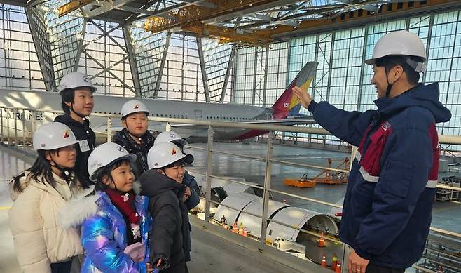 인천국제공항 아시아나항공 정비 격납고에서 ‘Why? 항공과학 탐험교실’ 행사에 참가한 아시아나항공·대한항공 직원 자녀들에게 현직 정비사가 항공기에 대해 설명하고 있다. ⓒ아시아나항공