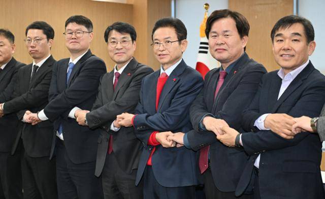 이철우(오른쪽에서 세 번째) 경북지사와 김정기(오른쪽에서 네 번째) 대구시장 권한대행 행정부시장 등이 지난달 20일 경북 안동시 경북도청에서 열린 대구·경북 행정통합 추진협의 회의에서 손을 맞잡고 있다. 경북도 제공