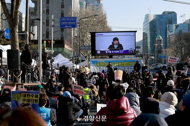 법원이 12·3 불법계엄과 관련해 내란 우두머리 혐의로 기소된 윤석열 전 대통령의 1심에서 무기징역을 선고한 19일 서울중앙지방검찰청 앞에서 시민들이 선고 방송을 시청하고 있다. 문재원 기자