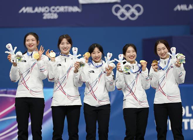 18일(현지시간) 이탈리아 밀라노 아이스스케이팅 아레나에서 열린 2026 밀라노-코르티나담페초 동계올림픽 쇼트트랙 여자 3000m 계주 결승에서 금메달을 따낸 한국 선수들이 메달을 목에 걸고 환하게 웃고 있다.  오른쪽부터 최민정, 김길리, 이소연, 노도희, 심석희.  [연합]