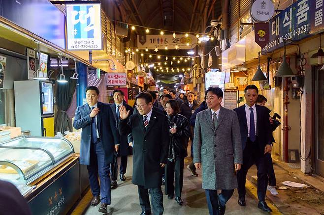 [서울=뉴시스] 최동준 기자 = 이재명 대통령이 9일 서울 종로구 통인시장을 방문해 상인들과 인사하고 있다.이번 일정은 최근 일부 경제지표가 개선되는 흐름을 보이고 있지만 장바구니 물가 등 체감경기가 여전히 어렵다는 국민들의 목소리를 현장에서 직접 듣기 위해 마련됐다. (사진=청와대 제공) 2026.02.09. photo@newsis.com *재판매 및 DB 금지