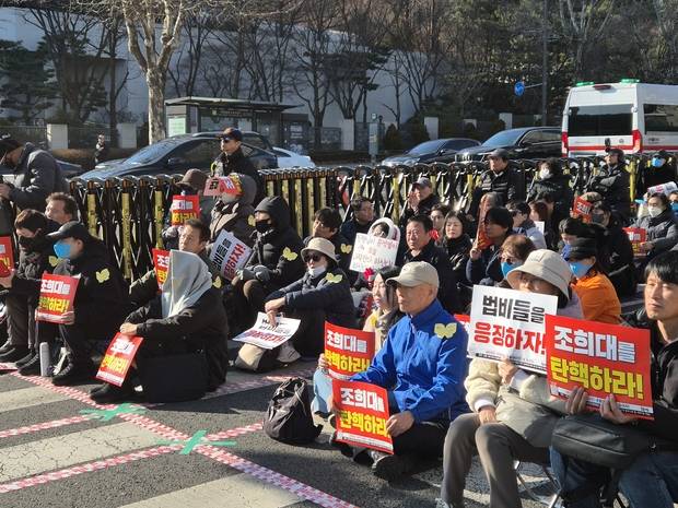 윤석열 전 대통령 내란 혐의 1심 선고 당일인 19일 서울 서초동 서울중앙지방법원 인근에서 개최된 진보 성향 단체 집회에 참석한 시민들이 사법부를 규탄하는 내용의 피켓을 들고 있다. 김지원 견습기자