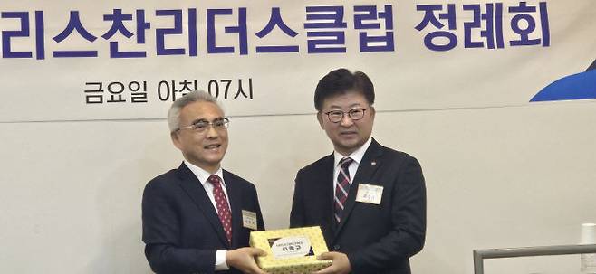 이희학 대표회장이 신입회원인  최충규 대덕구청장에게 성경책을 선물하고 있다.