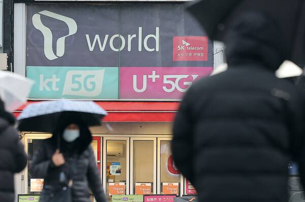2025년 12월 23일 오후 서울의 한 휴대폰 매장 앞으로 시민이 지나가고 있다. / 뉴스1