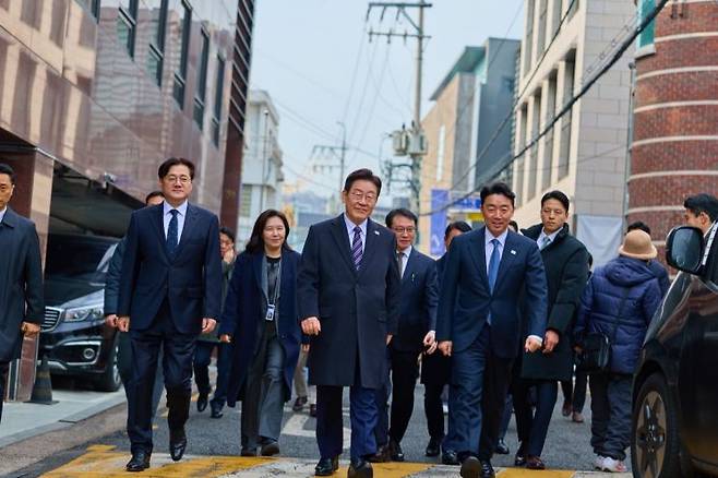 이재명 대통령이 12일 참모진과 함께 식사를 위해 청와대 인근 식당으로 향하고 있다. 연합뉴스