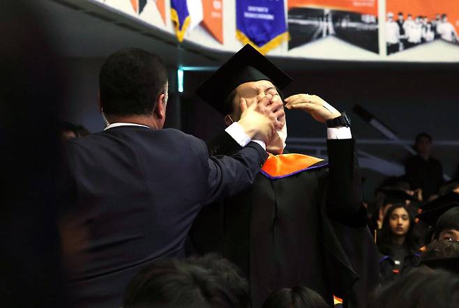 16일 대전 유성구 카이스트(KAIST)에서 열린 2024년 학위수여식에서 한 석사 졸업생이 축사 중인 윤석열 대통령에게 R&D 예산 복원 등을 요구하며 자리에서 일어나 항의하다 제지 당하고 있다. 2024.02.16 대전=뉴시스