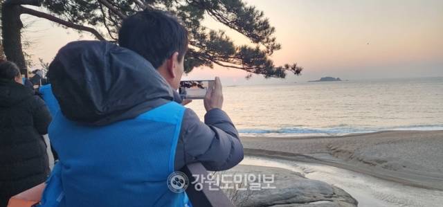 ▲ 때마침 떠오른 붉은 일출을 정성껏 사진에 담는 모습이 아름답다.