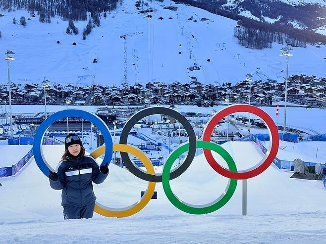 박희진 밀라노·코르티나담페초 동계올림픽 파크&파이프 기술총괄책임자(Technical Delegate)가 이탈리아 리비뇨 스노파크에 설치된 올림픽 오륜기 조형물 앞에서 포즈를 취하고 있다. 본인 제공