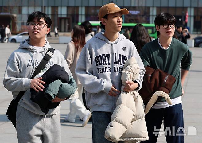 [서울=뉴시스] 이영환 기자 = 포근한 날씨를 보인 20일 오후 서울 종로구 광화문광장에서 외투를 손에 든 시민들이 걸어가고 있다. 2026.02.20. 20hwan@newsis.com