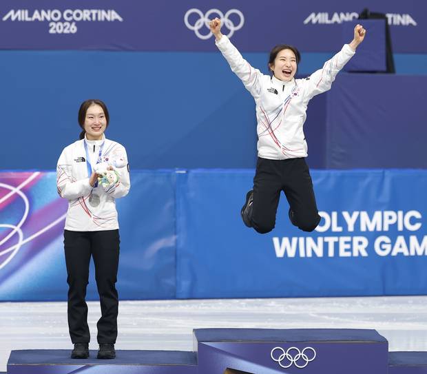 김길리(오른쪽)가 20일(현지 시간) 이탈리아 밀라노 아이스스케이팅 아레나에서 열린 2026 밀라노ㆍ코르티나담페초 동계올림픽 쇼트트랙 여자 1500m 시상식에서 펄쩍 뛰어오르며 금메달을 자축하고 있다. 왼쪽은 후배를 축하해주는 은메달 최민정. 연합뉴스
