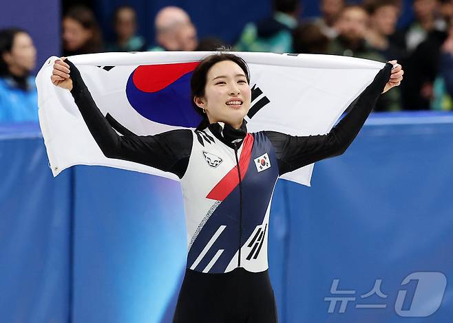 쇼트트랙 김길리가 20일(현지시간) 이탈리아 밀라노 아이스 스케이팅 아레나에서 열린 2026 밀라노·코르티나담페초 동계올림픽 쇼트트랙 여자 1500m 결승에서 금메달을 확보한 후 태극기를 두른 채 인사하고 있다. 2026.2.21 ⓒ 뉴스1 김진환 기자
