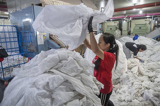 접경지의 세탁업체에서 이주노동자들이 서울 숙박업소에서 수거한 빨랫감을 분류하고 있다.(2018년 9월)