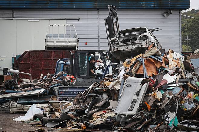 DMZ 인근의 폐차장에서 이주노동자가 지게차로 고철이 된 폐차를 옮기고 있다.(2016년 10월)