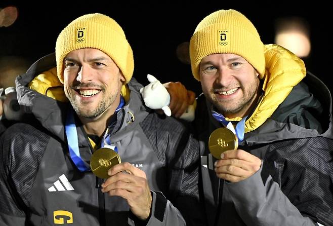 요하네스 로흐너(오른쪽)와 게오르그 플라이슈하우어(독일)가 17일(현지시간) 이탈리아 코르티나담페초에서 열린 2026 밀라노·코르티나 동계올림픽 남자 2인승 봅슬레이 시상식에서 금메달을 들어 보이고 있다. EPA 연합뉴스