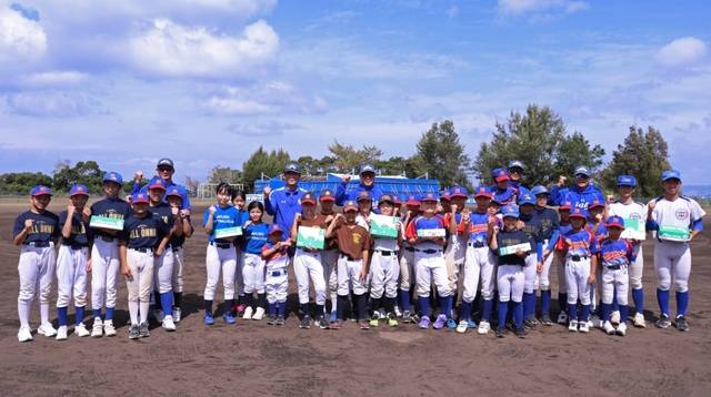 박진만 삼성 라이온즈 감독과 코치진이 22일 스프링캠프가 진행 중인 일본 오키나와 온나손의 학생들에게 새 연식 구와 소프트볼 구를 전달한 뒤 학생들과 기념사진을 찍고 있다. 삼성 라이온즈 제공