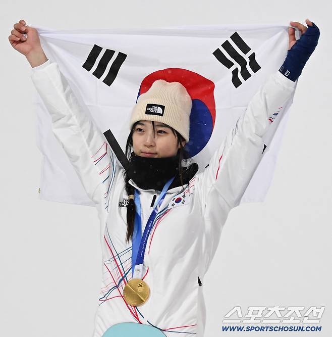 13일(한국시간) 이탈리아 리비뇨 스노파크에서 열린 스키 스노보드 여자 하프파이프 결선에서 최가온이 90.25점을 획득해 금메달을 차지했다. 시상식에서 태극기를 들어보이는 최가온. 리비뇨(이탈리아)=송정헌 기자songs@sportschosun.com/2026.02.13/