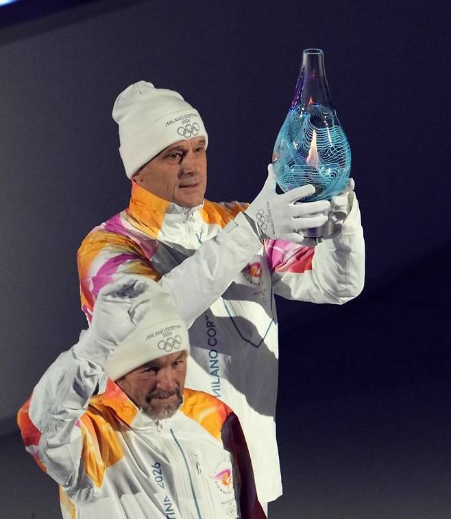 2026 밀라노·코르티나 동계올림픽 성화가 유리병에 담겨 23일(한국시간) 폐회식이 열린 '아레나 디 베로나' 안으로 옮겨지고 있다.      [사진 제공= 신화연합뉴스]