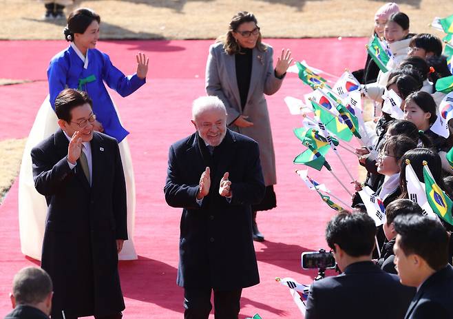 이재명 대통령 부부와 루이스 이나시우 룰라 다시우바 브라질 대통령 부부가 23일 청와대에서 열린 국빈 방한 공식환영식에서 어린이 환영단을 향해 인사하고 있다. 연합뉴스
