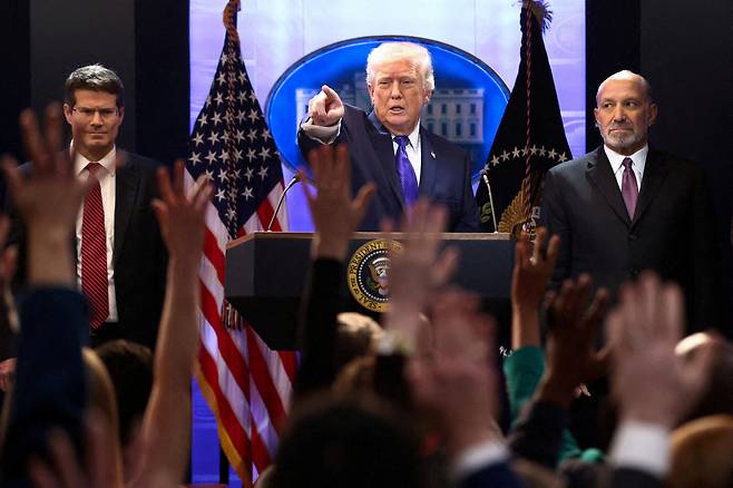 U.S. President Donald Trump, center, flanked by U.S. Secretary of Commerce Howard Lutnick, right, and U.S. Solicitor General D. John Sauer, holds a press briefing following the Supreme Court's ruling that Trump had exceeded his authority when he imposed tariffs at the White House in Washington on Feb. 20. [REUTERS/YONHAP]