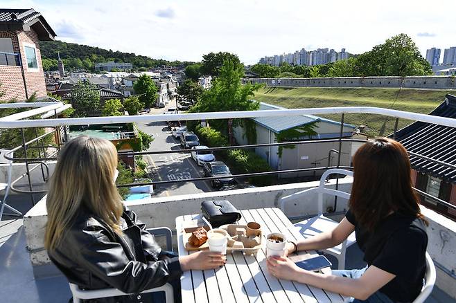 [수원=뉴시스] 경기 수원시 팔달구 행궁동의 한 루프톱 카페. 시민들이 화성행궁 성곽을 배경으로 차를 마시며 여유로운 시간을 보내고 있다. 과거 낙후된 원도심이었던 행궁동은 2013년 생태교통 축제 이후 '행리단길'로 불리는 관광명소로 탈바꿈했다. (사진=수원시 제공) 2026.02.23. photo@newsis.com *재판매 및 DB 금지