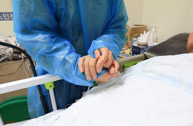 지난 10일 경기도 한 요양병원에서 간병을 하던 한 환자의 가족이 손을 꼭 잡고 있다. / 고운호 기자