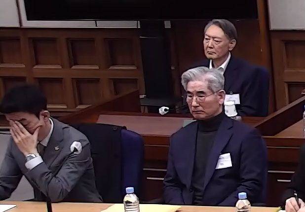 윤석열 전 대통령이 지난 19일 서울중앙지방법원 417호 대법정에서 열린 내란 우두머리 혐의 사건 1심 선고 공판에서 굳은 표정으로 앉아 있다. 윤 전 대통령에게 무기징역이 선고됐다. 오른쪽 아래는 김용현 전 국방부 장관. [서울중앙지법 제공]