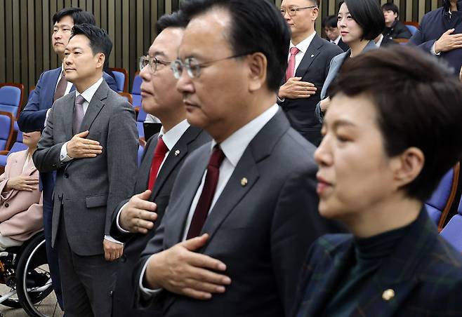 장동혁 대표를 비롯한 국민의힘 의원들이 23일 국회에서 열린 의원총회에서 국기에 경례하고 있다. 연합뉴스