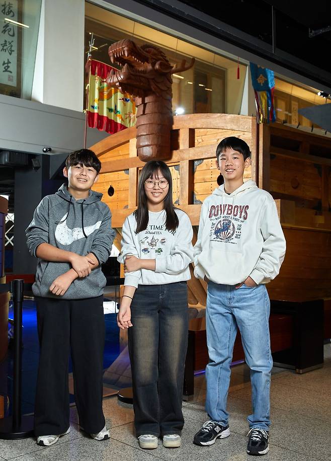이순신을 다시 알아보는 시간을 가진 홍원교·정하은·이서준(왼쪽부터) 학생기자가 거북선 모형 앞에 섰다.