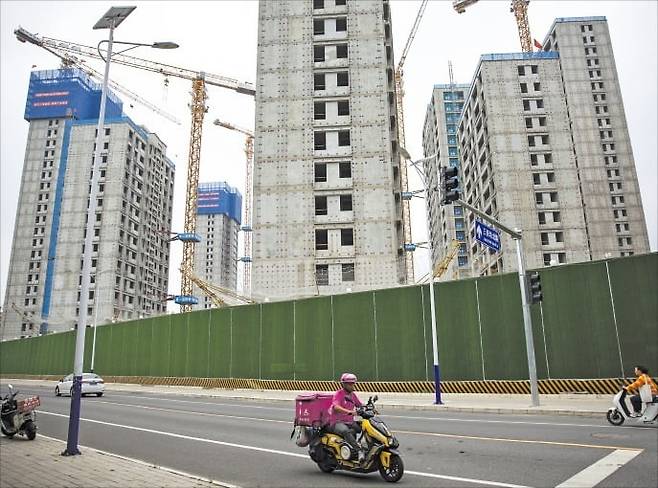 중국 베이징에서 건설 중인 아파트 단지 옆으로 오토바이가 지나가고 있다. EPA연합뉴스