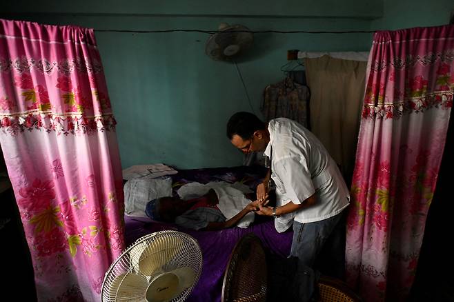 지난해 11월 한 쿠바 의사가 수도 아바나에서 환자 자택에서 진료하고 있다. 로이터연합뉴스