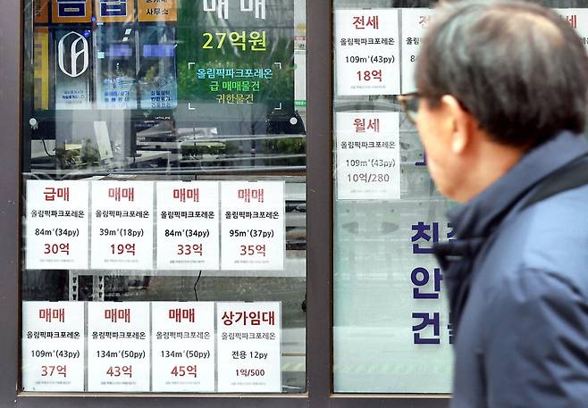 24일 최고가 대비 6억원 이상 싼 매물이 나온 '올림픽파크포레온' 근처 공인중개업소 앞을 행인이 지나가고 있다. 김재훈 기자