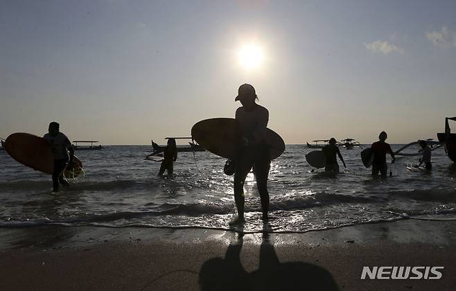 [쿠타 비치( 인도네시아)=AP/뉴시스]인도네시아 발리 섬의 명승지 쿠타 비치에서 서핑 객들이 석양의 바다에서 나오고 있다. 2023. 08.29.