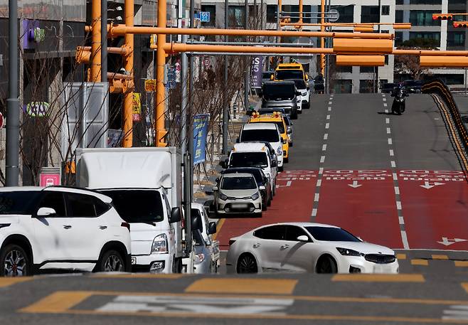 선명한 ‘어린이 보호구역’ 글자가 무색하게도 도로는 이미 거대한 주차장으로 변해 있었다. 황색 실선을 가볍게 넘어선 승용차들이 붉은 아스팔트 위를 빽빽하게 점령한 모습이다. /이용선기자 photokid@kbmaeil.com