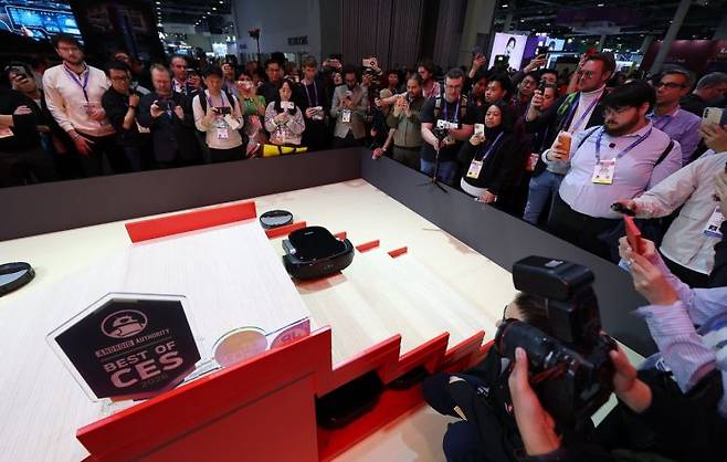 CES 개막 2일째인 지난달 7일(현지시간) 미국 네바다주 라스베이거스 베네시안 컨벤션센터의 로보락 부스에서 로봇청소기가 계단을 오르고 있다. 연합뉴스.