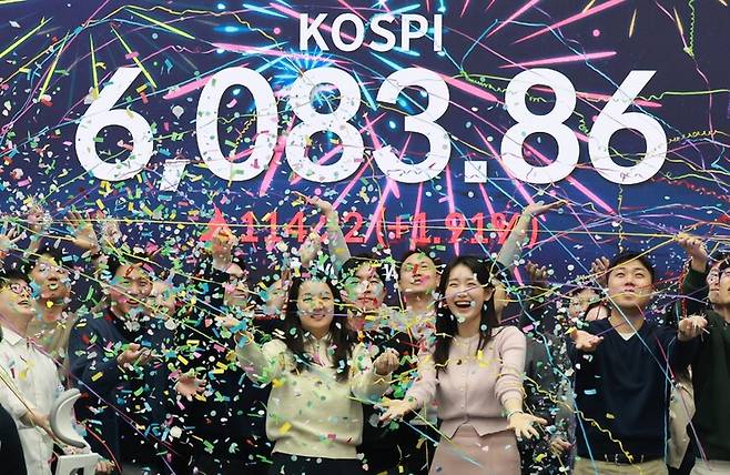 코스피가 사상 처음으로 6000을 넘어선 25일 오후 서울 중구 우리은행 딜링룸에서 직원들이 기뻐하고 있다. 이날 코스피는 6022.70으로 출발해 114.22(1.91%) 오른 6083.86에 거래를 마쳤다. 정용일 선임기자 yongil@hani.co.kr