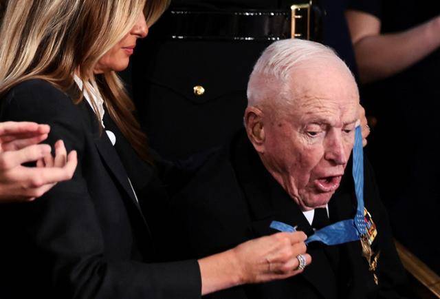 24일 미국 워싱턴 국회의사당에서 진행된 도널드 트럼프 대통령의 국정연설 도중 로이스 윌리엄스 퇴역 미 해군 대령의 목에 영부인 멜라니아 트럼프 여사가 명예훈장을 걸고 있다. 워싱턴=로이터 연합뉴스