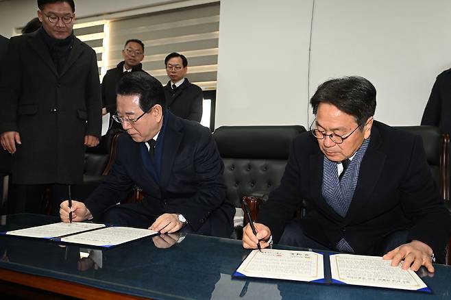 강기정 광주시장(오른쪽)과 김영록 전남지사가 지난달 2일 광주 국립5·18민주묘지에서 광주·전남 통합 선언문에 서명하고 있다. [뉴시스]