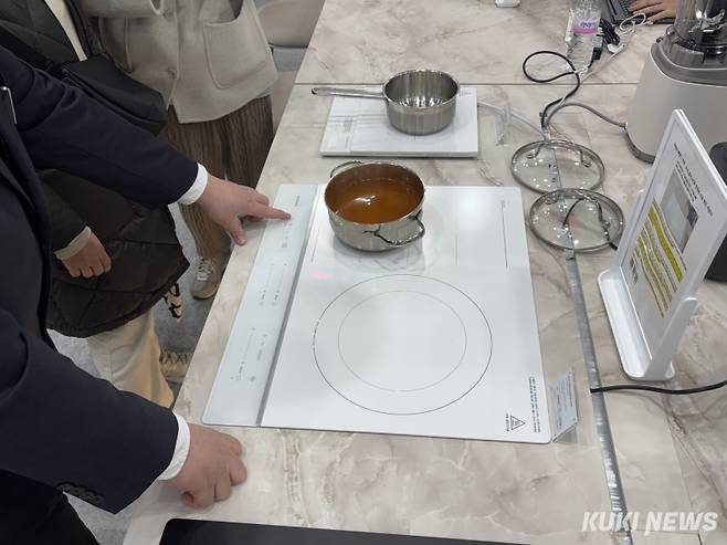 2026 서울리빙디자인페어 쿠쿠 부스에서 방문객들이 ‘AI 프리존 인덕션 레인지’의 AI 사운드 감지 센서 물끓임 방지 기술을 시연해보고 있다. 이다빈 기자