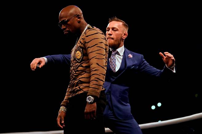 코너 맥그리거(오른쪽)가 지난 2017년 7월 플로이드 메이웨더와 복싱 맞대결 전 월드 프레스 투어 도중 뒤통수를 치려는 듯한 제스처를 취하고 있다. [게티이미지]