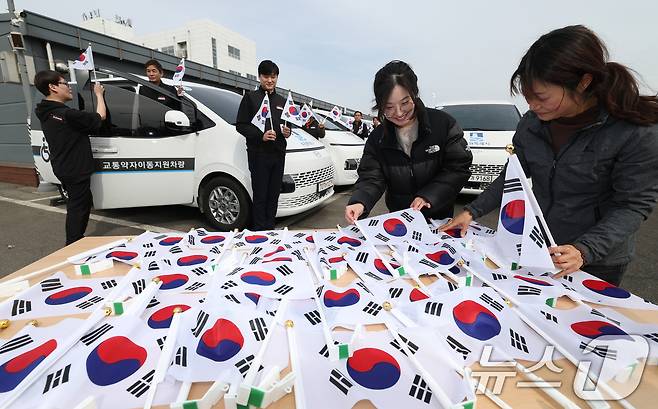 제107주년 3·1절을 사흘 앞둔 26일 경기 수원시 권선구 수원시교통약자지원센터 한아름콜에서 직원들이 3·1절을 맞아 교통약자지원차량에 부착할 태극기를 준비하고 있다. 2026.2.26 ⓒ 뉴스1 김영운 기자
