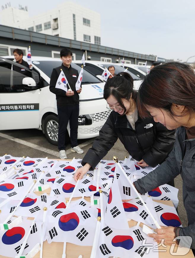 제107주년 3·1절을 사흘 앞둔 26일 경기 수원시 권선구 수원시교통약자지원센터 한아름콜에서 직원들이 3·1절을 맞아 교통약자지원차량에 부착할 태극기를 준비하고 있다. 2026.2.26 ⓒ 뉴스1 김영운 기자