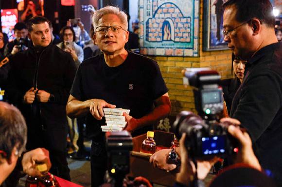 엔비디아 최고경영자(CEO) 젠슨 황이 2026년 1월 31일 대만 타이베이에서 대만 기술기업 최고경영자들과의 만찬을 주최하기에 앞서 언론 관계자들에게 음식을 건네고 있다 [사진=연합뉴스]