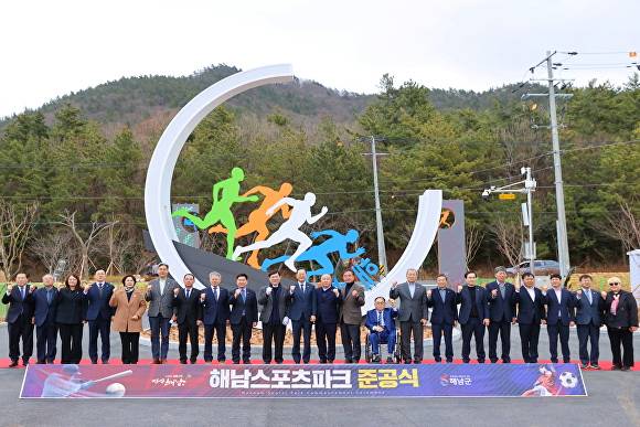 26일 전남 해남군에서 진행된 해남스포츠파크 준공식에서 관계자들이 현수막 뒤에서 파이팅을 하고 있다. [사진=해남군]