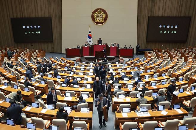 25일 국회에서 열린 2월 임시국회 본회의에 '법왜곡죄'를 포함한 형법 일부개정법률안(대안)이 상정된 뒤 국민의힘 조배숙 의원이 무제한 토론을 시작하자 더불어민주당 의원들이 본회의장을 떠나고 있다. 연합뉴스