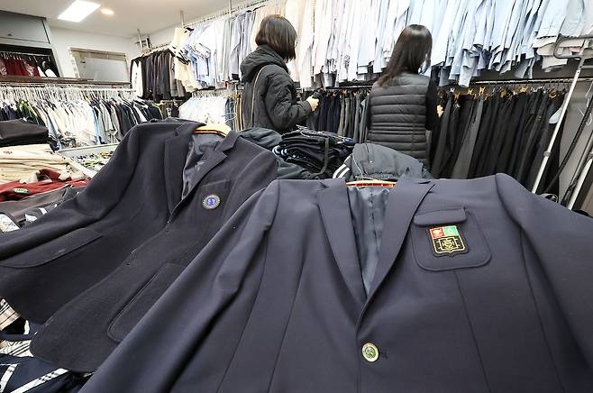 교육 당국이 교복 가격을 바로잡기 위해 전국 학교를 상대로 한 교복비 전수조사에 들어간 가운데 23일 관내 학교와 졸업생에게 교복을 기증받아 필요로 하는 주민에게 저렴하게 판매하는 서울 송파구 '나눔교복매장'을 찾은 학부모가 교복 등을 살펴보고 있다. 이재명 대통령은 지난 12일 "최근 교복 구입비가 60만원에 육박한다고 한다"며 "개학을 앞둔 만큼 교복 가격의 적정성 문제를 한번 살펴봐 달라"고 지시했다. 연합뉴스
