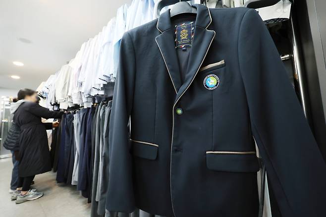 한 학부모가 지난 26일 서울 송파구 나눔교복매장을에서 교복을 고르고 있다. 연합뉴스