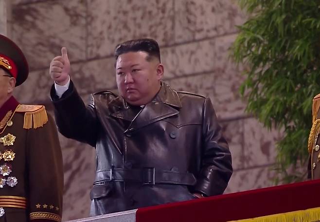 김정은 국무위원장이 지난 25일 밤 평양 김일성광장에서 열린 노동당 제9차대회 기념 열병식 주석단에서 열병종대 행진을 지켜보며 엄지손가락을 치켜들고 있다. 연합뉴스