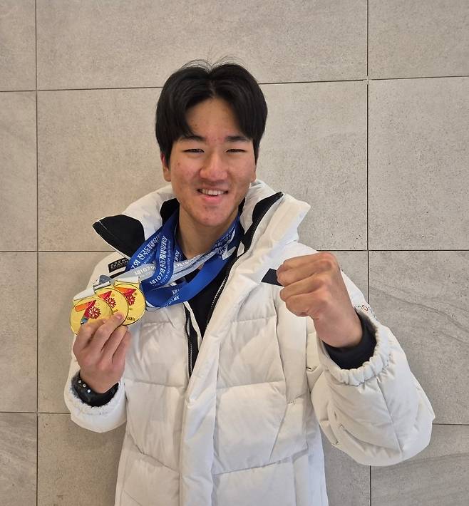 제107회 전국동계체육대회 바이애슬론 남자 대학부에서 3관왕에 오른 조나단(한국방송통신대)이 금메달 3개를 걸고 기념사진을 촬영하고 있다.