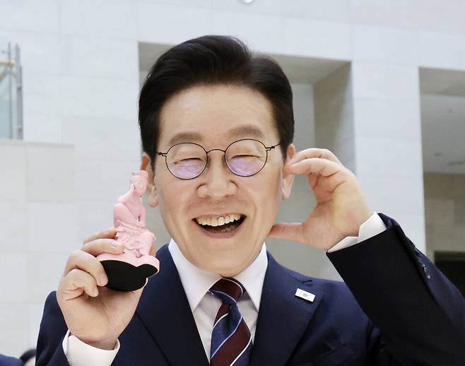 이재명 대통령이 2026년 2월26일 서울 용산구 국립중앙박물관에서 열린 특별전 ‘우리들의 이순신\'을 관람한 뒤 상품관에서 기념품을 들고 포즈를 취하고 있다. 연합뉴스
